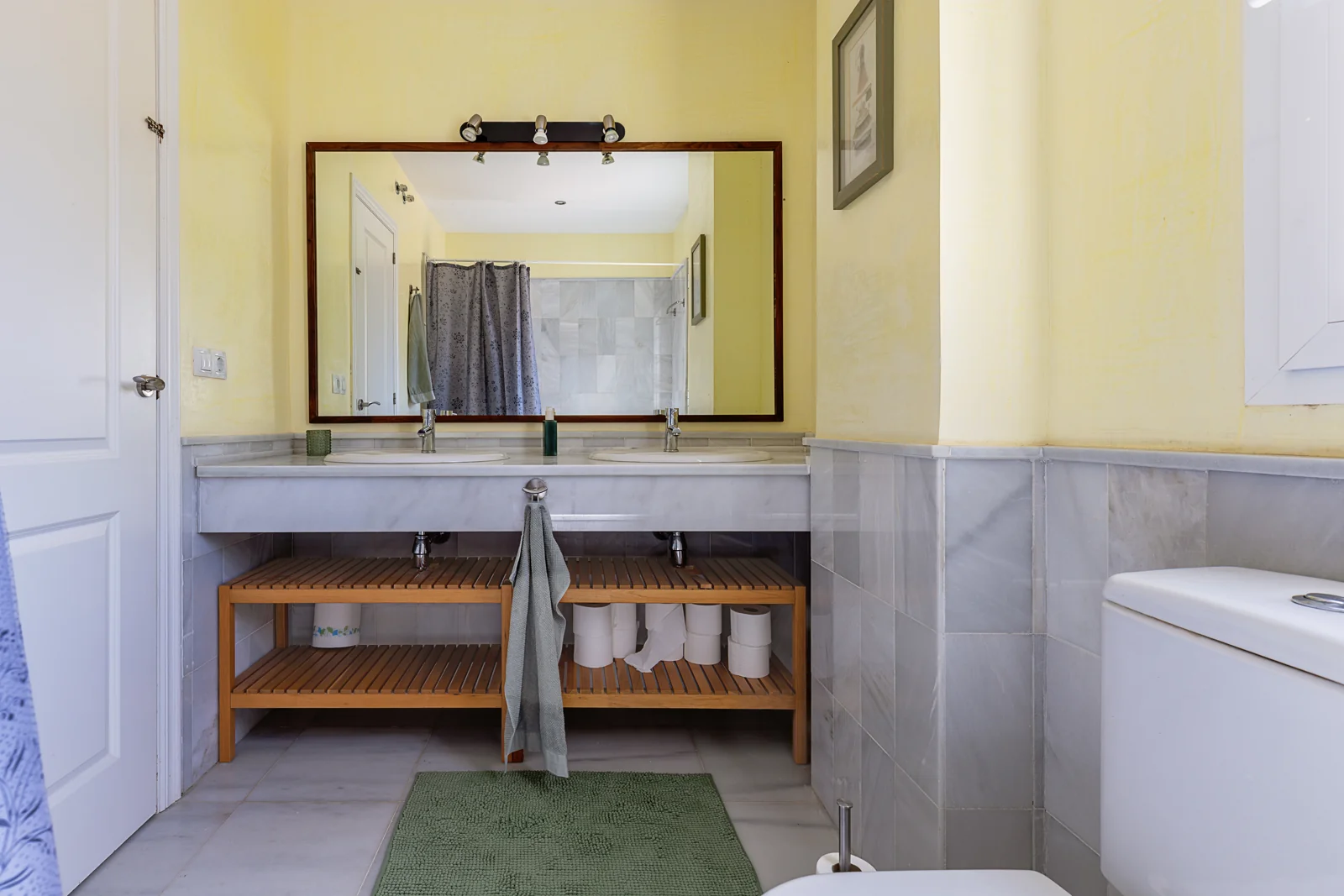 Bathroom with a double basin, mirror and window in a Nuevo Portil villa