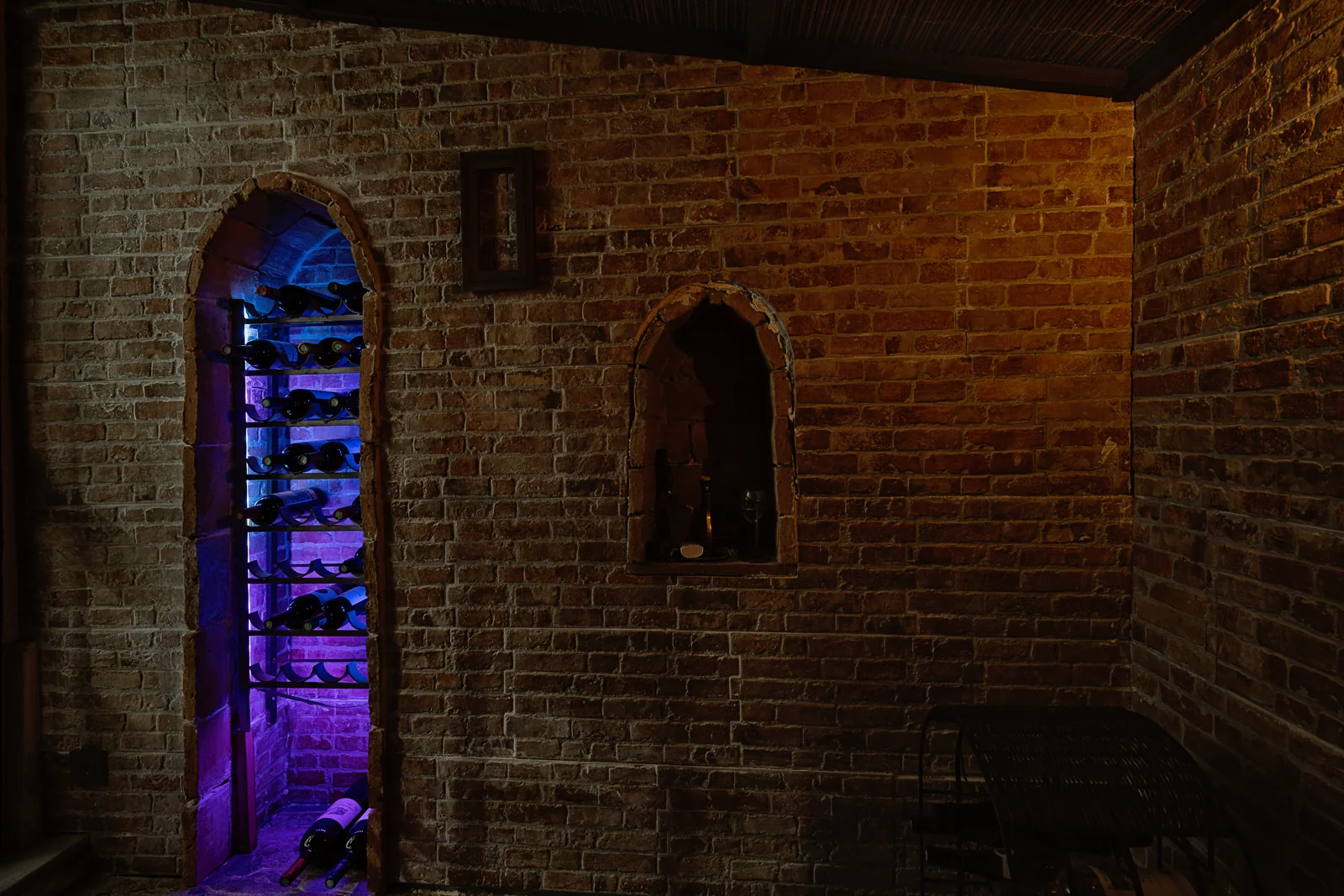 Brick wine cellar with an illuminated wine rack in a Nuevo Portil villa