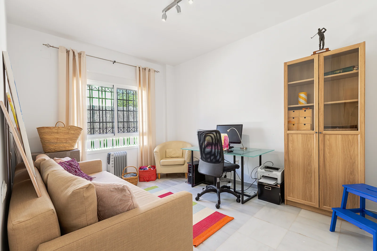 Study with a sofa, desk and large window in a Nuevo Portil villa