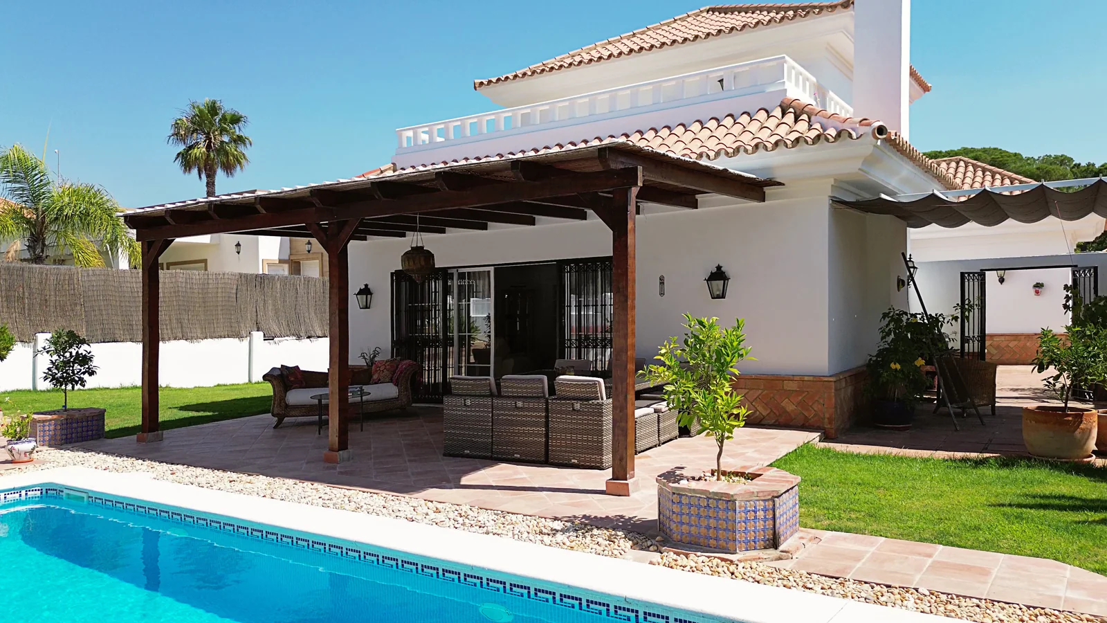 Covered veranda beside the pool and garden of a Nuevo Portil villa